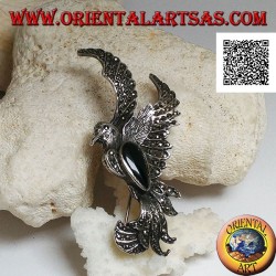 Silver brooch in the shape of a phoenix in flight in profile studded with marcasite and with a drop of onyx