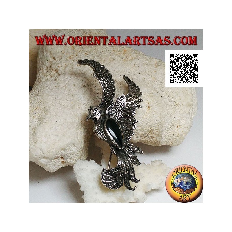 Broche de plata con forma de fénix en vuelo de perfil tachonado de marcasita y con una gota de ónix