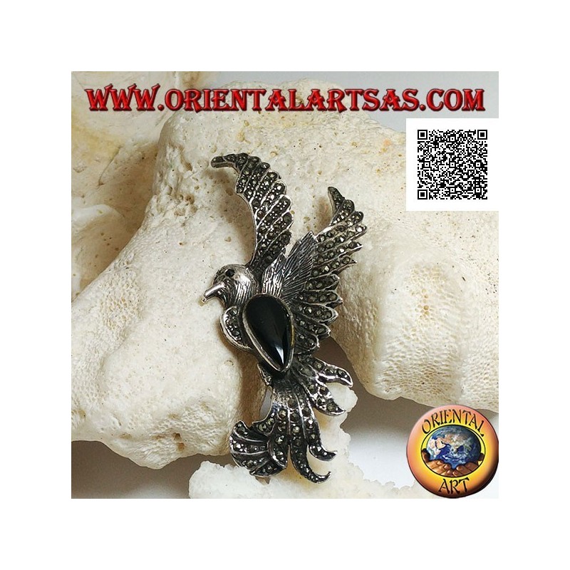 Broche en argent en forme de phénix en vol de profil parsemé de marcassite et d'une goutte d'onyx