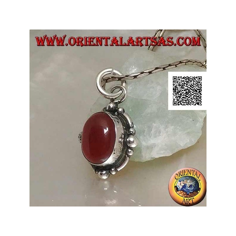 Colgante de plata con una cornalina de cabujón ovalada rodeada de plata con una bola en los cuatro puntos cardinales