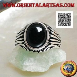 Silver ring with oval onyx cabochon surrounded by dots and stripes engraved on the sides