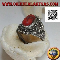 Anillo de plata con coral tibetano antiguo en un entorno nepalí con Garuḍa (dios progenitor de las aves) a los lados