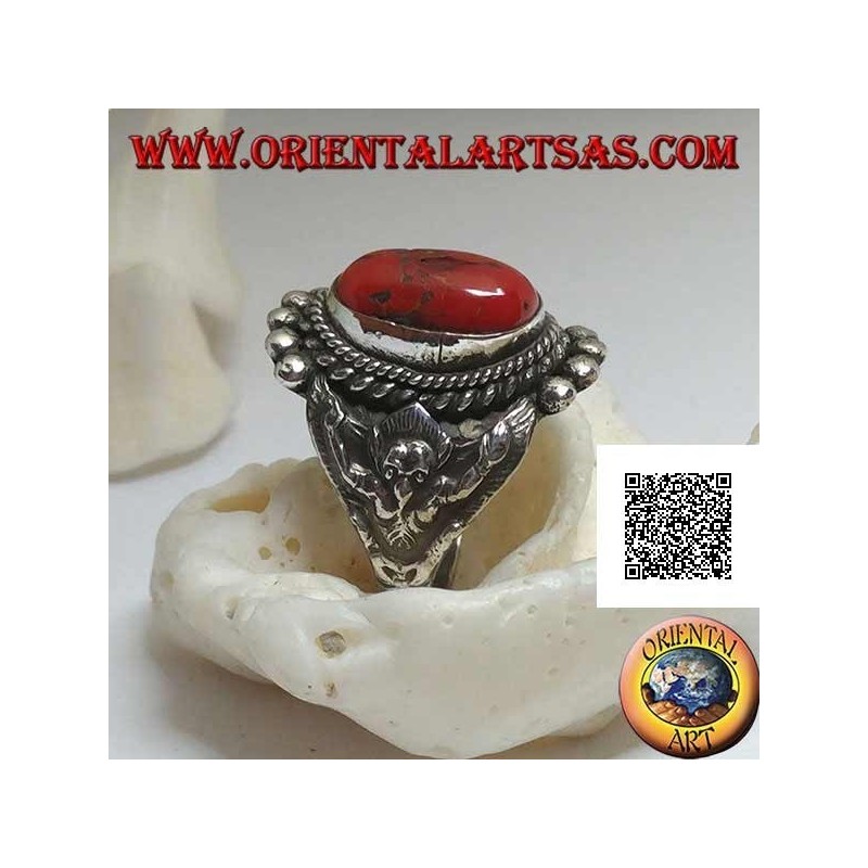 Anillo de plata con coral tibetano antiguo en un entorno nepalí con Garuḍa (dios progenitor de las aves) a los lados