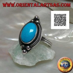 Silver ring with cabochon oval turquoise surrounded by interweaving on a plate and three balls above and below