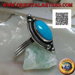 Silver ring with cabochon oval turquoise surrounded by interweaving on a plate and three balls above and below