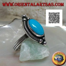 Silver ring with cabochon oval turquoise surrounded by interweaving on a plate and three balls above and below