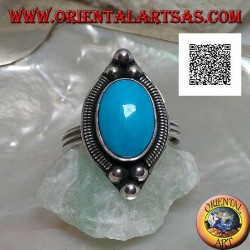 Silberring mit ovalem Cabochon-Türkis, umgeben von einer Verflechtung auf einem Teller und drei Kugeln oben und unten