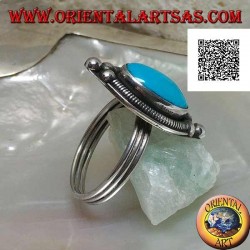 Silberring mit ovalem Cabochon-Türkis, umgeben von einer Verflechtung auf einem Teller und drei Kugeln oben und unten