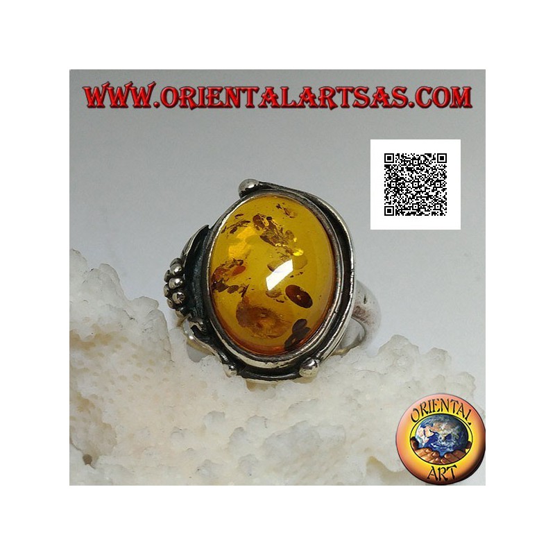 Silver ring with cabochon oval amber with two balls and a leaf on the edge