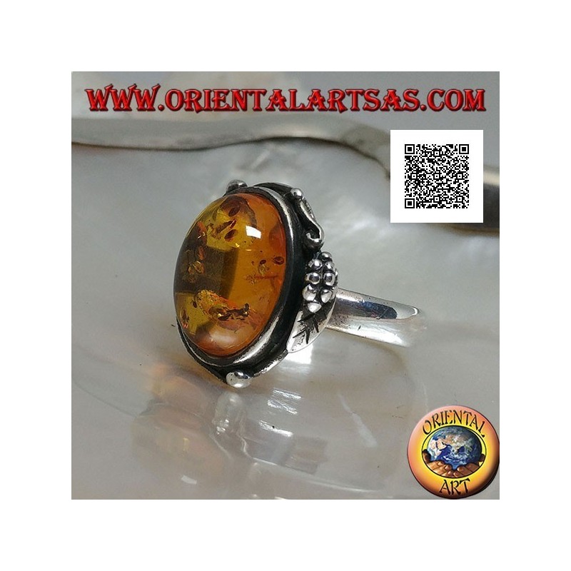 Silver ring with cabochon oval amber with two balls and a leaf on the edge