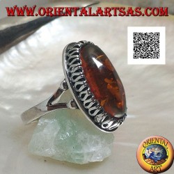 Silver ring with elongated oval amber surrounded by a serpentine in relief