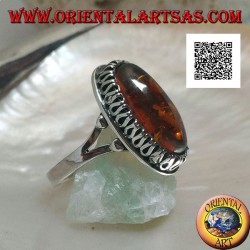 Silver ring with elongated oval amber surrounded by a serpentine in relief