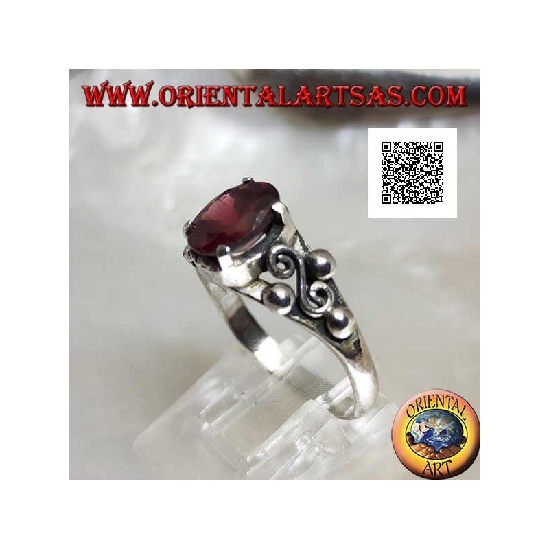 Silver ring with oval garnet set and spiral S between three balls on the sides