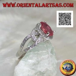 Silver ring with natural oval ruby set between wavy intersecting lines studded with zircons