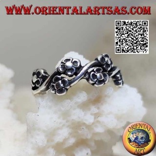 Anillo de plata con pares de pequeñas flores en una línea ondulada