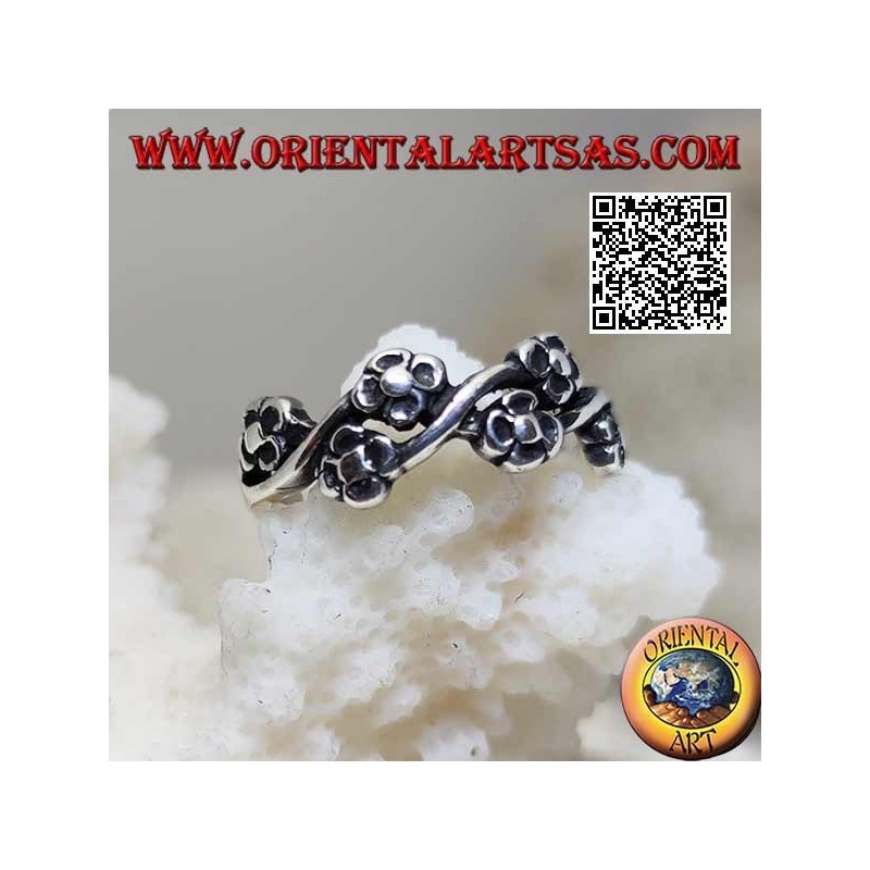 Silver ring with pairs of small flowers on a wavy line