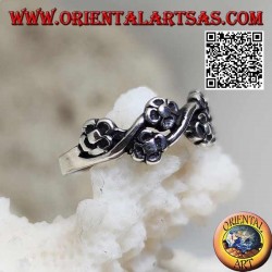 Anillo de plata con pares de pequeñas flores en una línea ondulada