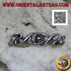 Broche de plata en forma de dos serpientes entrelazadas con ónix central y en los ojos