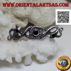 Broche de plata en forma de dos serpientes entrelazadas con ónix central y en los ojos