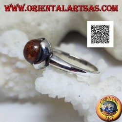 Bague en argent avec cabochon rond d'ambre entouré de demi-cercles sur une monture lisse