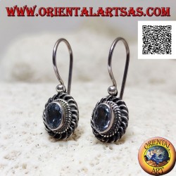Silver earrings with faceted oval blue topaz surrounded by interweaving and bas-relief quotation marks