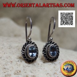 Silver earrings with faceted oval blue topaz surrounded by interweaving and bas-relief quotation marks