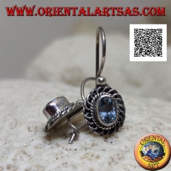 Silver earrings with faceted oval blue topaz surrounded by interweaving and bas-relief quotation marks