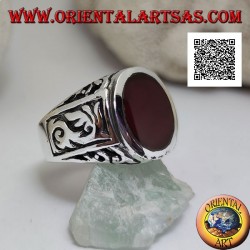 Bague en argent avec cornaline ovale au ras du bord avec des décorations gothiques en bas-relief sur les côtés