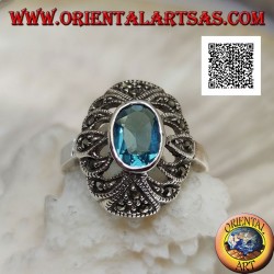 Silver ring with oval blue topaz on an openwork convex oval studded with marcasite