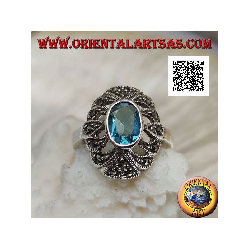 Silver ring with oval blue topaz on an openwork convex oval studded with marcasite