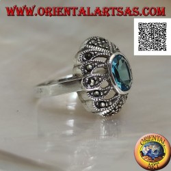 Silver ring with oval blue topaz on an openwork convex oval studded with marcasite