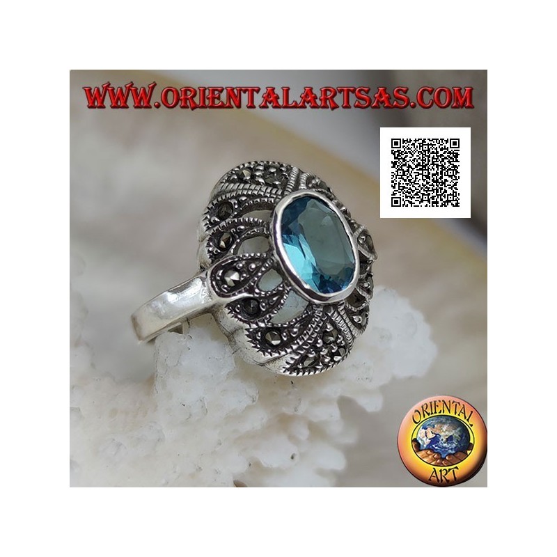 Silver ring with oval blue topaz on an openwork convex oval studded with marcasite