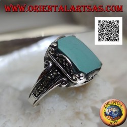 Bague en argent avec cabochon carré turquoise dans un cadre ondulé et marcassite sur et sur les côtés