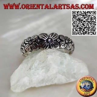 Silver ring with engraved band with growing row of four-petal flowers in relief