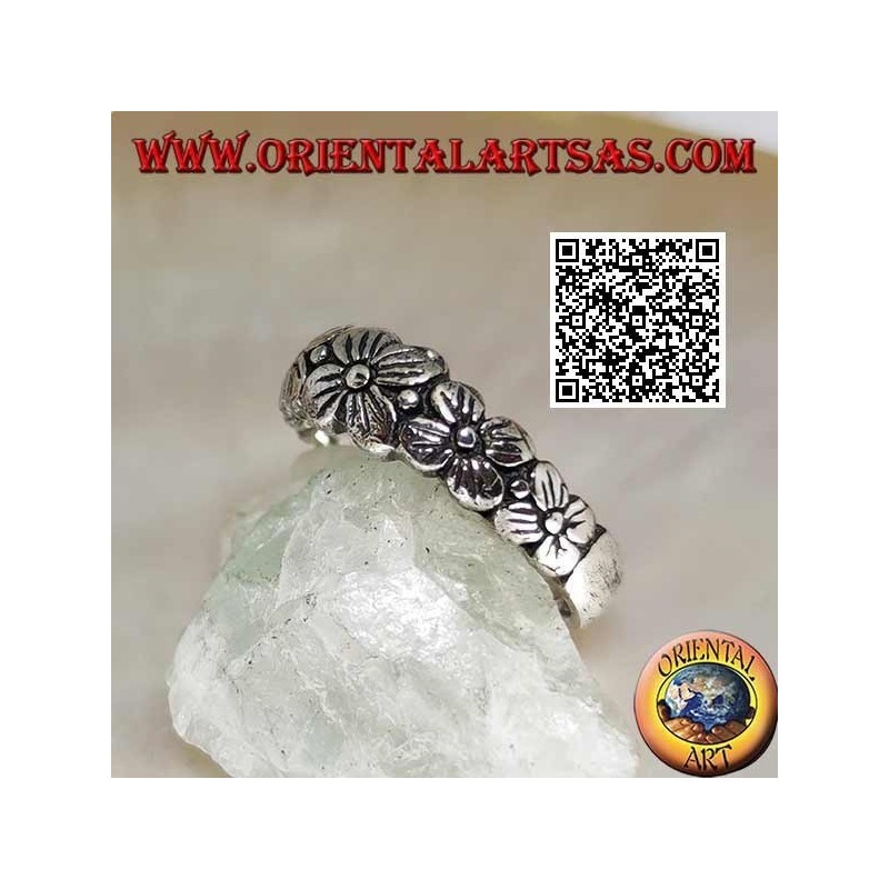 Silver ring with engraved band with growing row of four-petal flowers in relief
