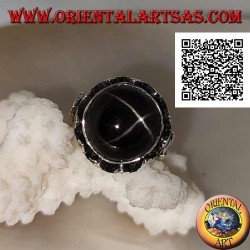 Anillo de plata con una estrella negra redonda en forma de cabujón en un marco de borde alto con trío de discos