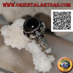 Anillo de plata con una estrella negra redonda en forma de cabujón en un marco de borde alto con trío de discos