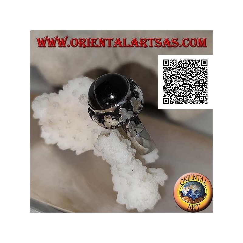 Anillo de plata con una estrella negra redonda en forma de cabujón en un marco de borde alto con trío de discos