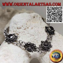 Silver bracelet of 7 flowers with central round faceted garnet joined by two chains