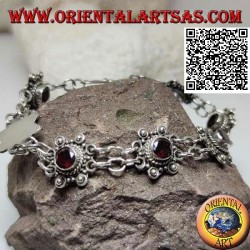Silver bracelet of 7 flowers with central round faceted garnet joined by two chains
