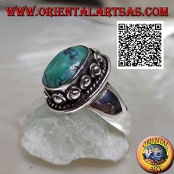 Silver ring with antique oval Tibetan turquoise surrounded by interweaving and ball in the donut