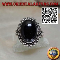 Silver ring with oval cabochon onyx surrounded by a double row of balls and balls on the sides