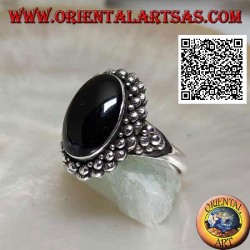 Silver ring with oval cabochon onyx surrounded by a double row of balls and balls on the sides