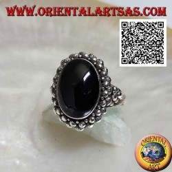 Silver ring with oval cabochon onyx surrounded by a double row of balls and balls on the sides