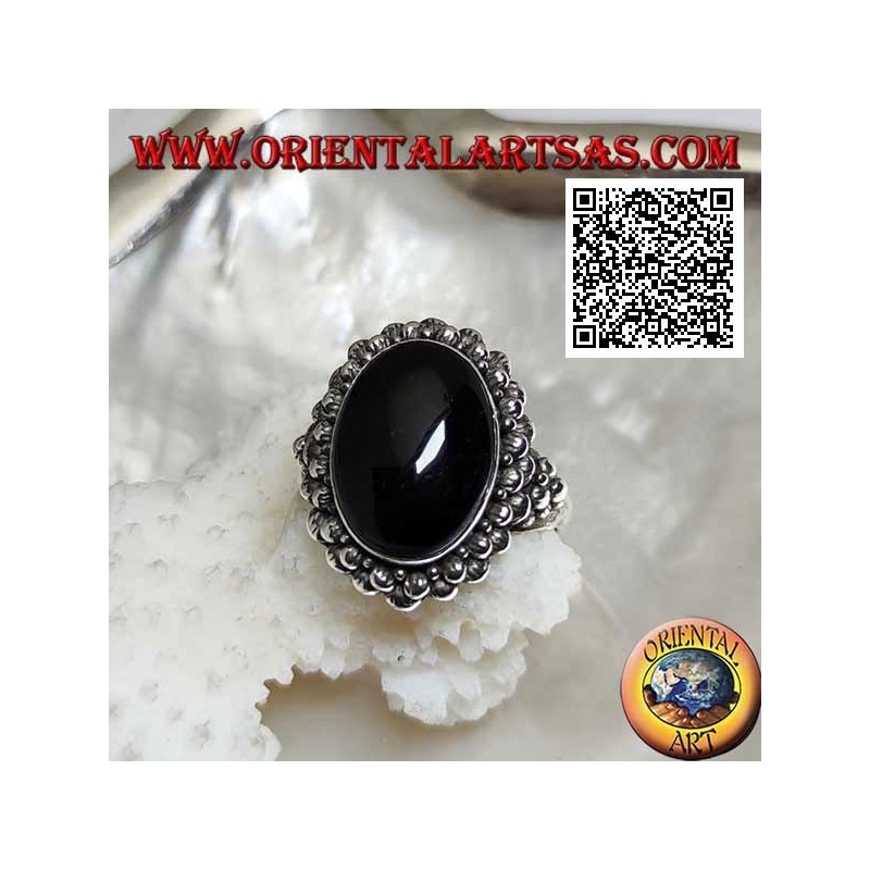 Silver ring with oval cabochon onyx surrounded by a double row of balls and balls on the sides