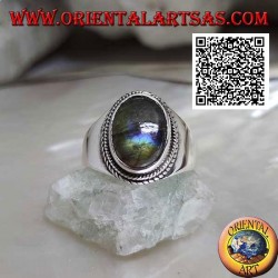 Silver band ring with oval labradorite surrounded by interweaving on a smooth setting