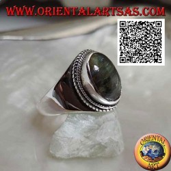 Anillo de plata con labradorita ovalada rodeada de entretejidos en un entorno suave