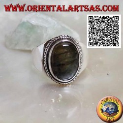 Anillo de plata con labradorita ovalada rodeada de entretejidos en un entorno suave