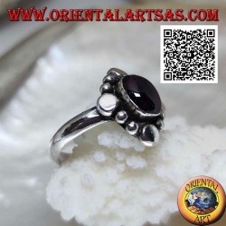 Silver ring with oval cabochon garnet surrounded by alternating studs and balls