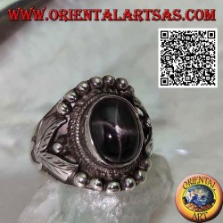 Silver ring with oval black star on ethnic setting with balls and leaves on the sides